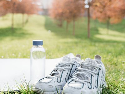 Sport shoes and water bottle on a clean wooden floor